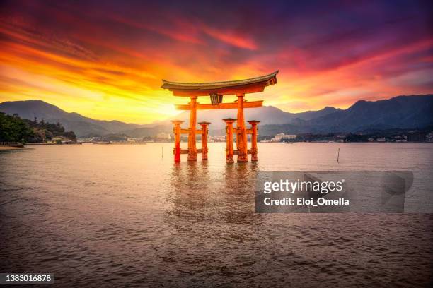 tramonto al santuario itsukushima miyajima, hiroshima, giappone - scintoismo foto e immagini stock
