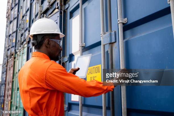 side of dock worker opening container cargo at yard - safe harbor stock pictures, royalty-free photos & images
