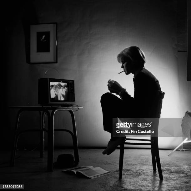 Singer David Sylvian, of English new romantic group, Japan, sitting on a chair, watching a portable television, London, January 1980.