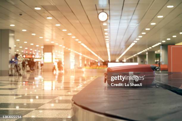 luggage on conveyor belt at airport - airport luggage fotografías e imágenes de stock