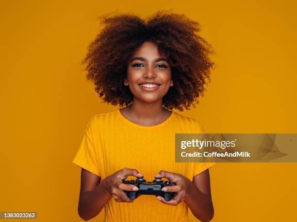 woman holding joystick and playing - 14 year old biracial girl curly hair stock pictures, royalty-free photos & images