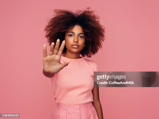 beautiful afro girl with curly hairstyle showing stop sign - shirt model stock pictures, royalty-free photos & images