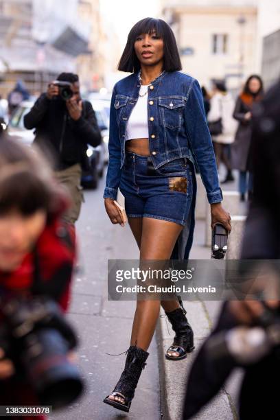 Venus Williams wearing a white crop top, denim jacket, denim shorts with Louis Vuitton monogram details, black Louis Vuitton clutch and black Louis...