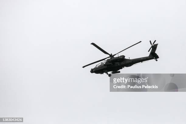 An Apache helicopter flies over Adazu military training ground during the Crystal Arrow 2022 exercise on March 8, 2022 in Adazi, Latvia....