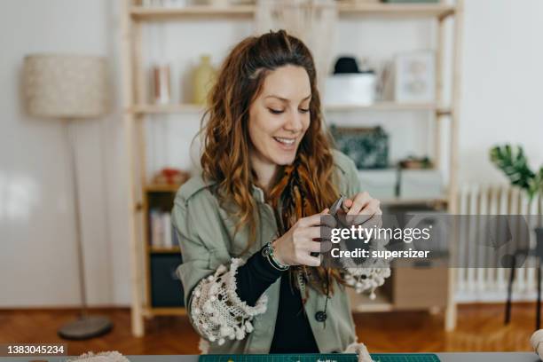 mujeres jóvenes haciendo joyas hechas a mano en el estudio - hacer cuentas fotografías e imágenes de stock