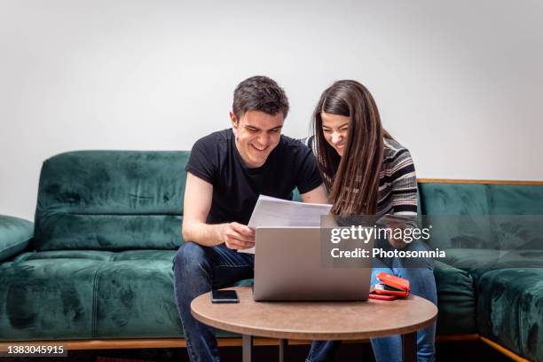 young couple paying bills online - refund stock pictures, royalty-free photos & images