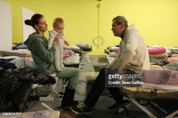 Anna Skolobanyova holds her son Bohdan as she chats with her father Yuri, all of whom fled Kyiv in war-torn Ukraine, at a temporary shelter where...