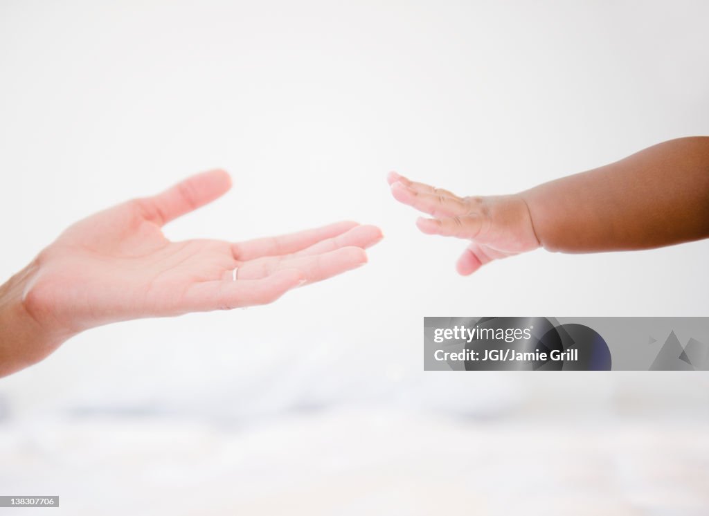 African American woman reaching out to baby boy