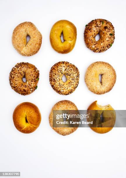 various bagels, one with bite missing - bagel - fotografias e filmes do acervo