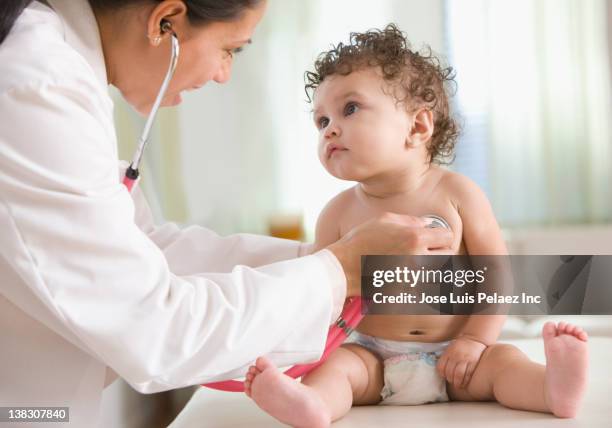 doctor examining baby girl - doctor and baby stock pictures, royalty-free photos & images