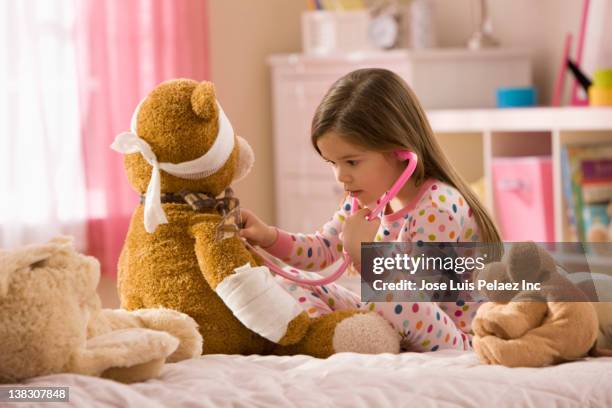 mixed race girl playing doctor with stuffed animal - bicho de pelúcia imagens e fotografias de stock