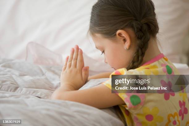 caucasian girl kneeling by bed praying - child praying stock pictures, royalty-free photos & images