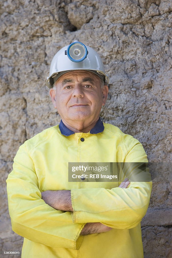 Hispanic miner in coat and hard-hat