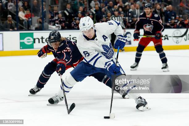 Patrik Laine of the Columbus Blue Jackets attempts to steal the puck from Mitchell Marner of the Toronto Maple Leafs during the game at Nationwide...