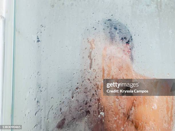 man in steamy bathroom taking a bath - bathroom clean closeup stock-fotos und bilder