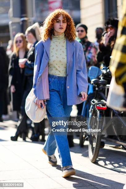 Guest wears a pale green with yellow and pink flower print pattern turtleneck pullover, a blue oversized blazer jacket, blue denim large pants, a...