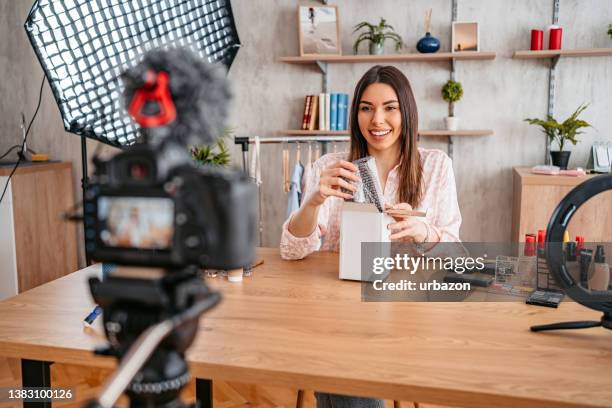 woman unboxing in live video - lichaamsverzorging en schoonheid stockfoto's en -beelden