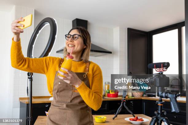 smiling woman taking a selfie as she prepares to start recording a video for her blog. - woman playing squash stock pictures, royalty-free photos & images