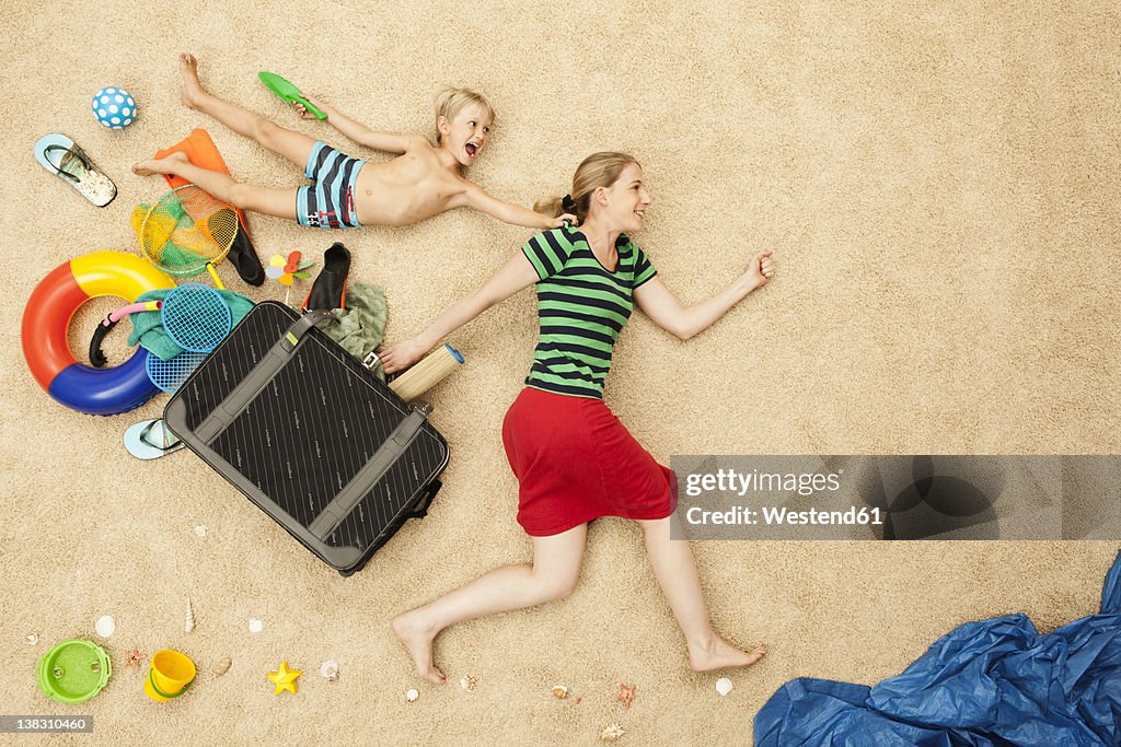 Germany, Mother and son with toys and baggage at beach