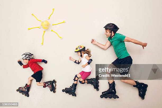 germany, artificial scene with family doing inline skating - roller en ligne photos et images de collection
