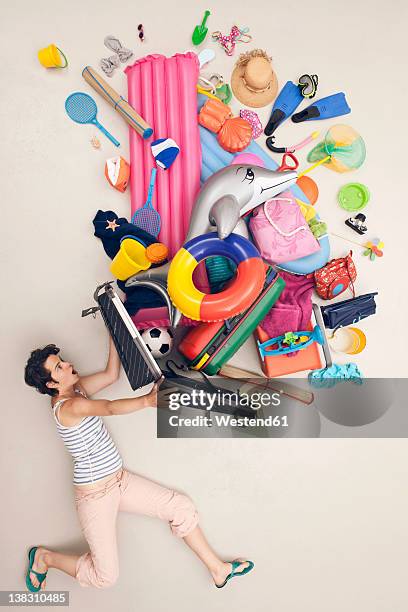 germany, artificial scene with woman opening baggage full of beach toys - lying down stockfoto's en -beelden