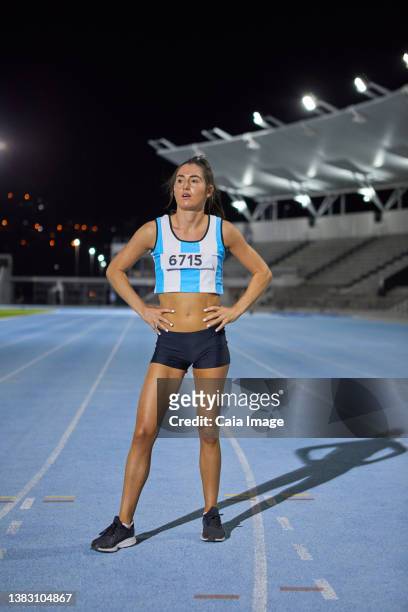female track and field athlete with hands on hips after competition - startnummer stock-fotos und bilder