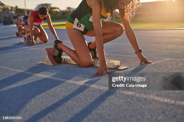 female track and field athletes ready at starting blocks on track - track starting block stock pictures, royalty-free photos & images