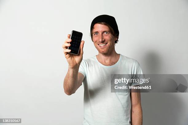 man holding mobile phone, smiling - showing smartphone stock pictures, royalty-free photos & images