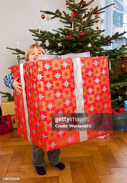 germany, munich, boy holding big christmas present - big toothy smile stock pictures, royalty-free photos & images