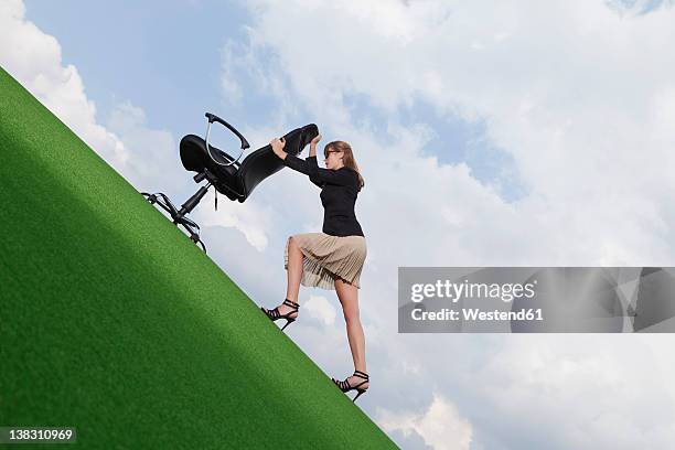 germany, bavaria, munich, businesswoman pushing chair on lawn - colina acima imagens e fotografias de stock