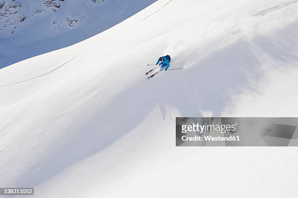 austria, zurs, lech, young man doing alpine skiing on arlberg mountain - lech stock-fotos und bilder