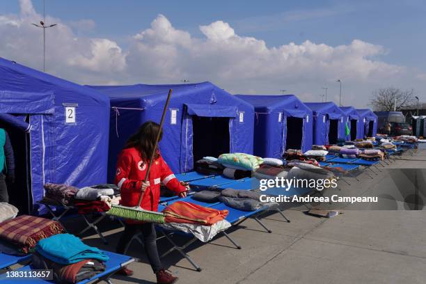 Romanian Red Cross volunteer helps clean the tents where refugees could rest after reaching the border, on March 8, 2022 in Isaccea, Romania....