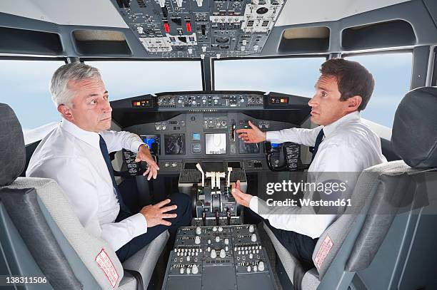 germany, bavaria, munich, pilot and co-pilot piloting aeroplane from airplane cockpit - co pilot fotografías e imágenes de stock