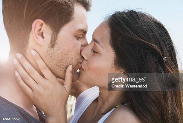 spain, majorca, young couple kissing on boardwalk, close up - peck 個照片及圖片檔
