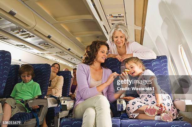 germany, munich, bavaria, people with cell phone in economy class airliner - plane taking off stock pictures, royalty-free photos & images