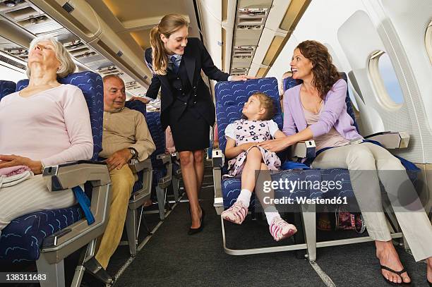 germany, munich, bavaria, passengers with stewardess in economy class airliner - hostess foto e immagini stock