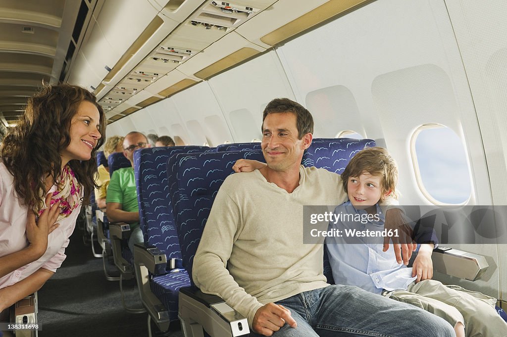 Germany, Munich, Bavaria, People talking in economy class airliner