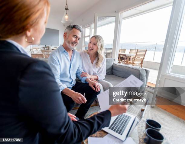 glückliches reifes paar, das investitionen und finanzberater zu hause trifft - testament schreiben stock-fotos und bilder