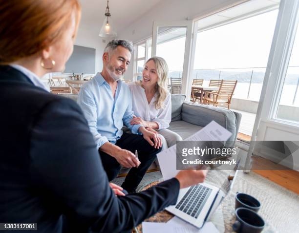 happy mature couple meeting investments and financial advisor at home - pensioen thema stockfoto's en -beelden