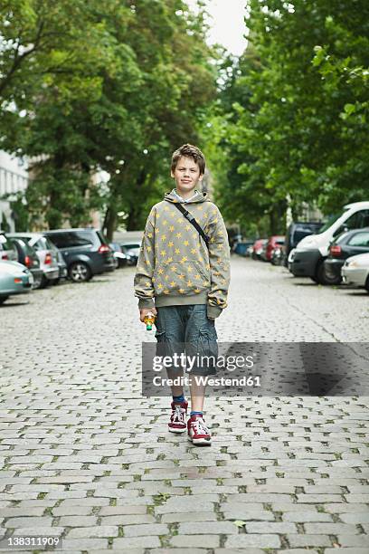 germany, berlin, boy standing in street - boy with car stock pictures, royalty-free photos & images