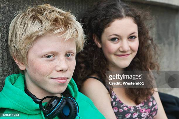 germany, berlin, teenage couple with headphone, smiling - young love stock-fotos und bilder