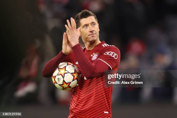 Robert Lewandowski of FC Bayern Muenchen celebrates with the match ball after scoring a hat-trick during the UEFA Champions League Round Of Sixteen...