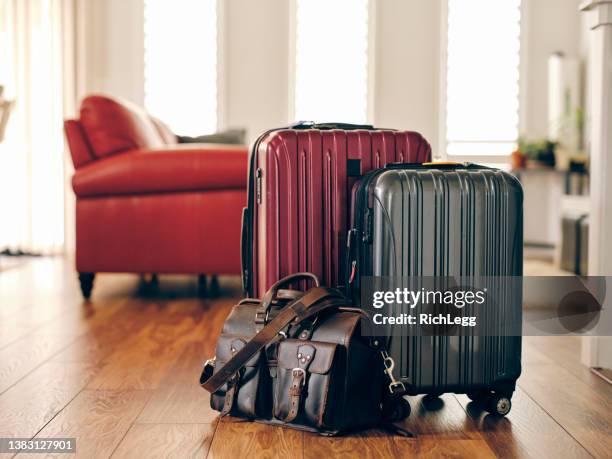 suitcases in a home ready for travel - holiday packing stockfoto's en -beelden