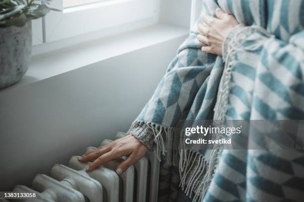 unwell woman feel cold in home with no heating - ac weary stockfoto's en -beelden