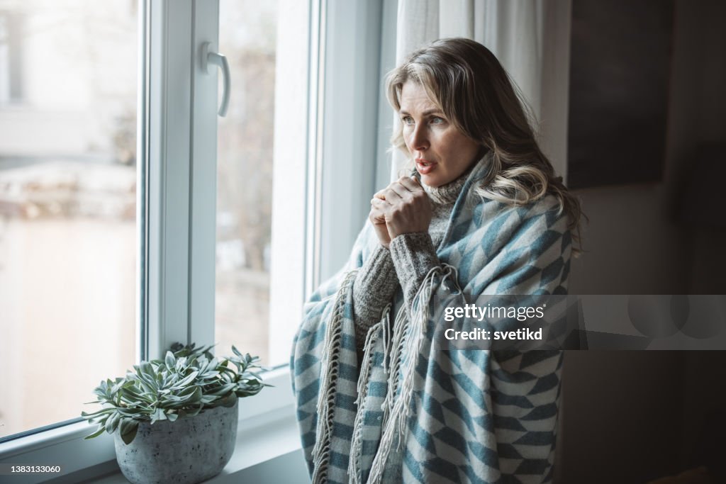 Unwell woman feel cold in home with no heating