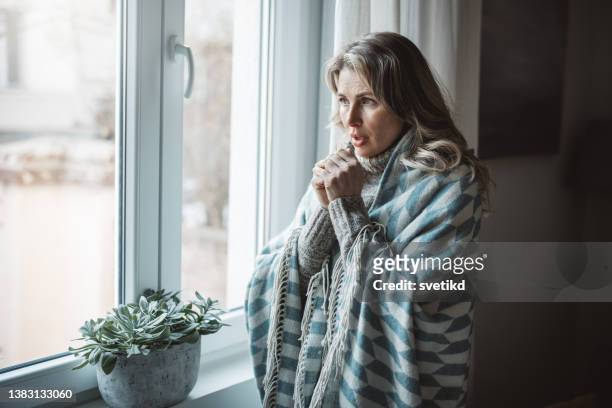 unwell woman feel cold in home with no heating - fever chills stock pictures, royalty-free photos & images