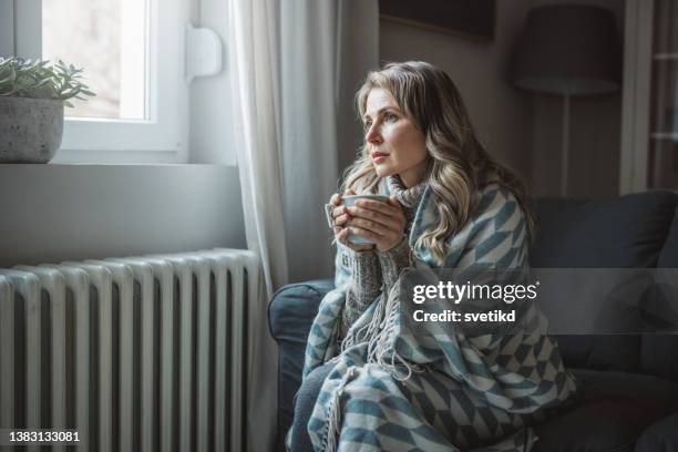 unwell woman feel cold in home with no heating - ac weary stockfoto's en -beelden