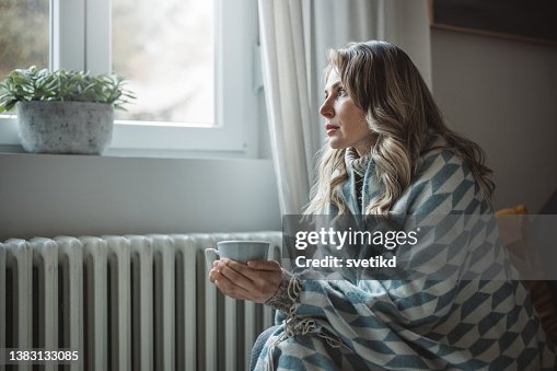 Unwell woman feel cold in home with no heating Unwell woman feel cold in home with no heating