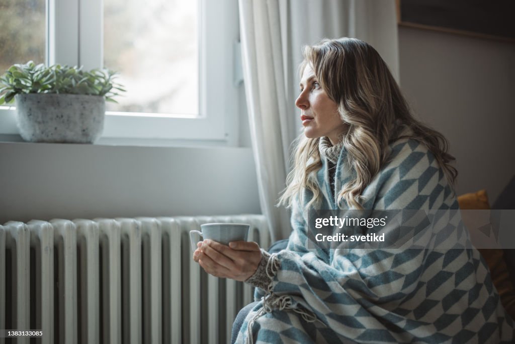 Unwell woman feel cold in home with no heating