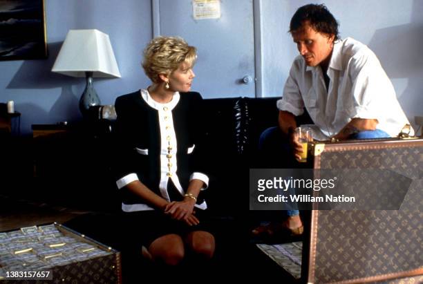 American stage and screen actress Kelly McGillis and American film and stage actor Peter Weller film a scene with a suitcase full of money during the...